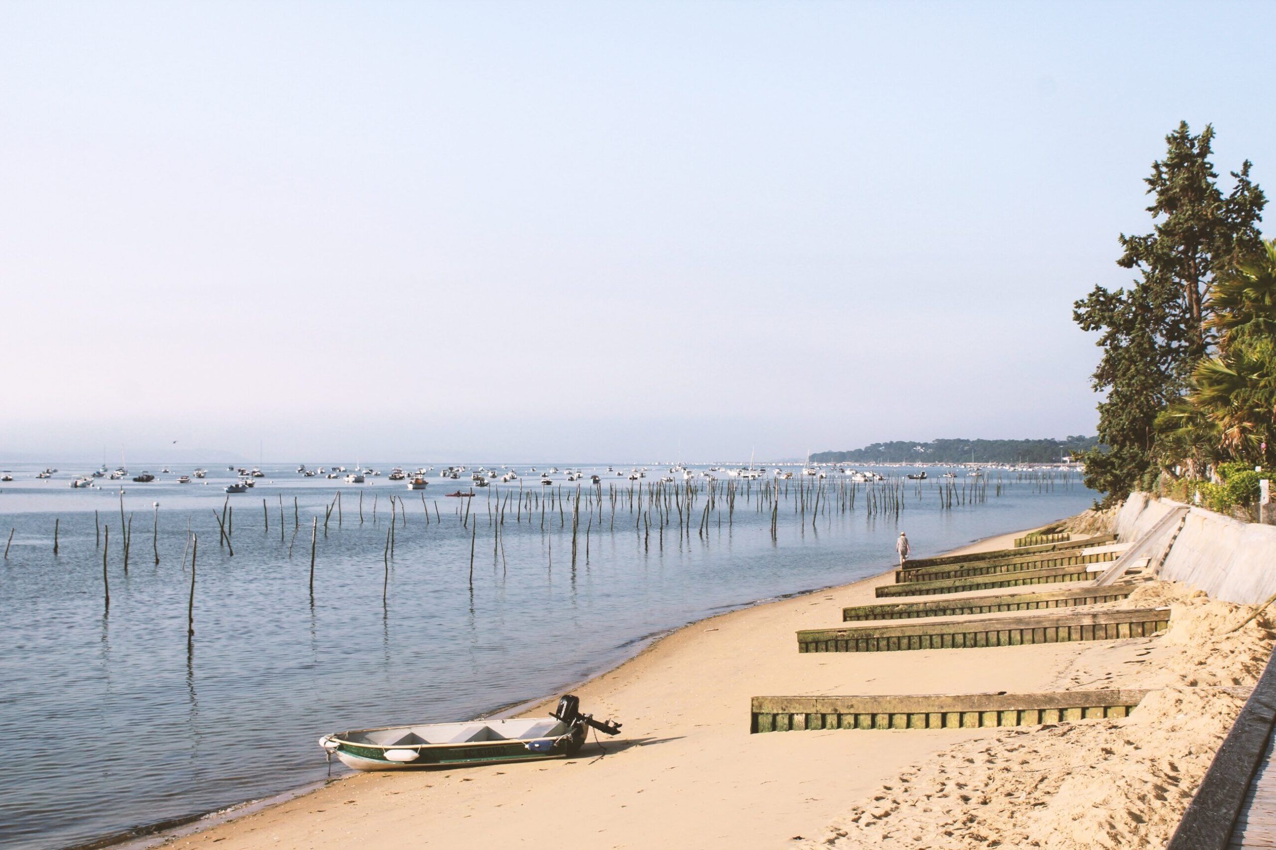 Plage du Bassin d’Arcachon côté Cap-Ferret, bateaux au mouillage et piquets à huîtres