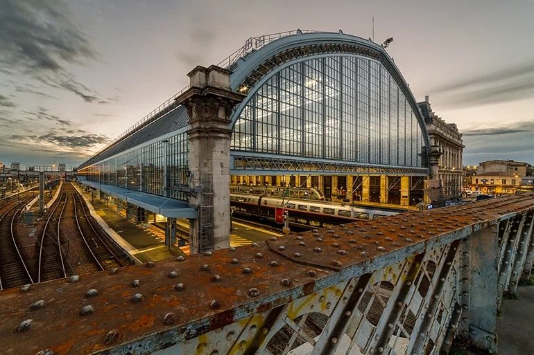 La grande halle vitrée de la gare de Bordeaux Saint-Jean au crépuscule