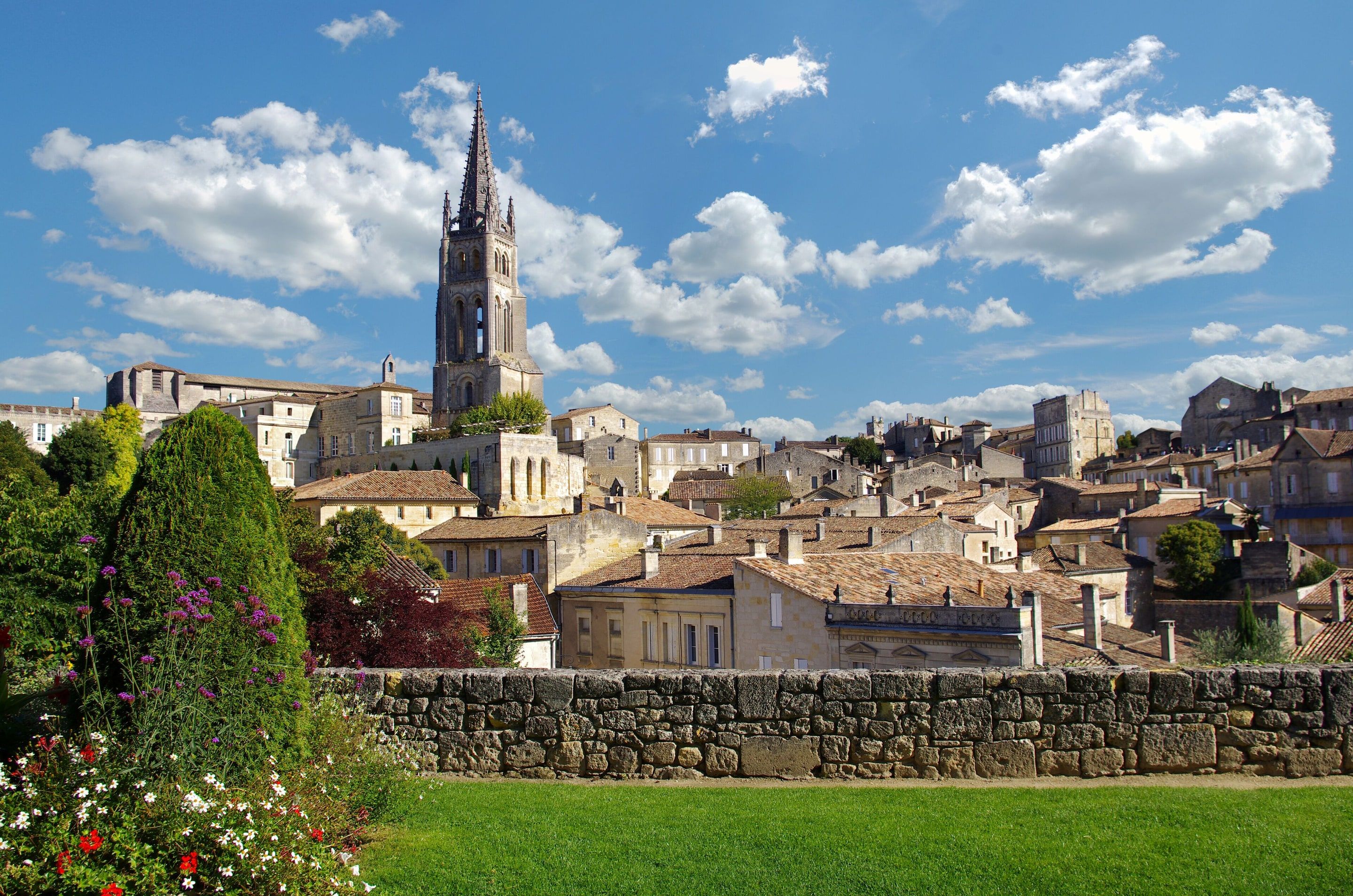 Toits de pierre blonde et clocher du Libournais sous un ciel bleu