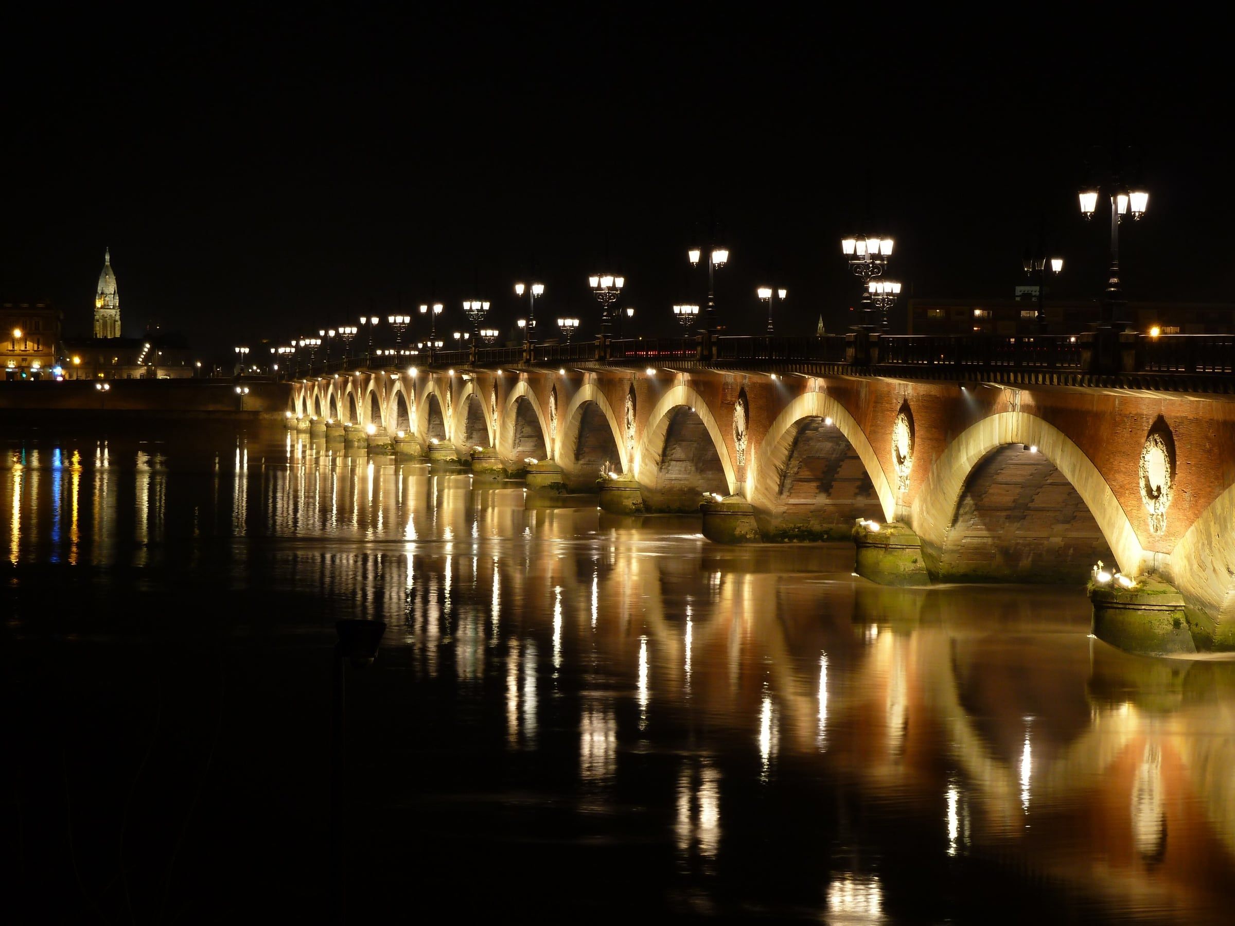 Le pont de pierre illuminé la nuit sur la Garonne
