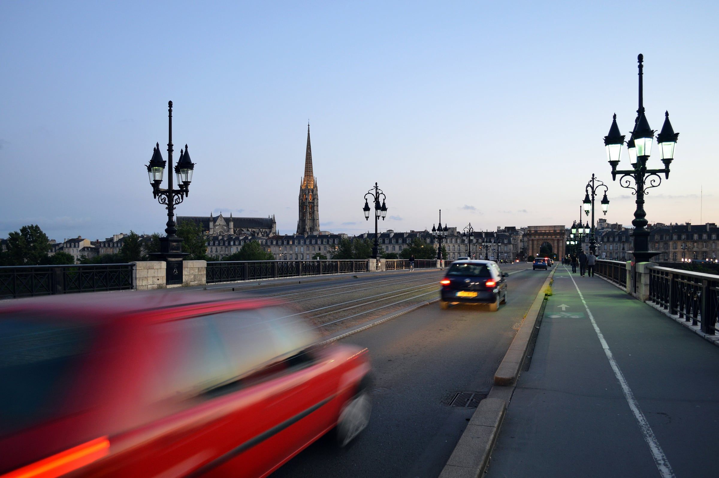 Voitures sur le pont de pierre au crépuscule, flèche Saint-Michel en fond